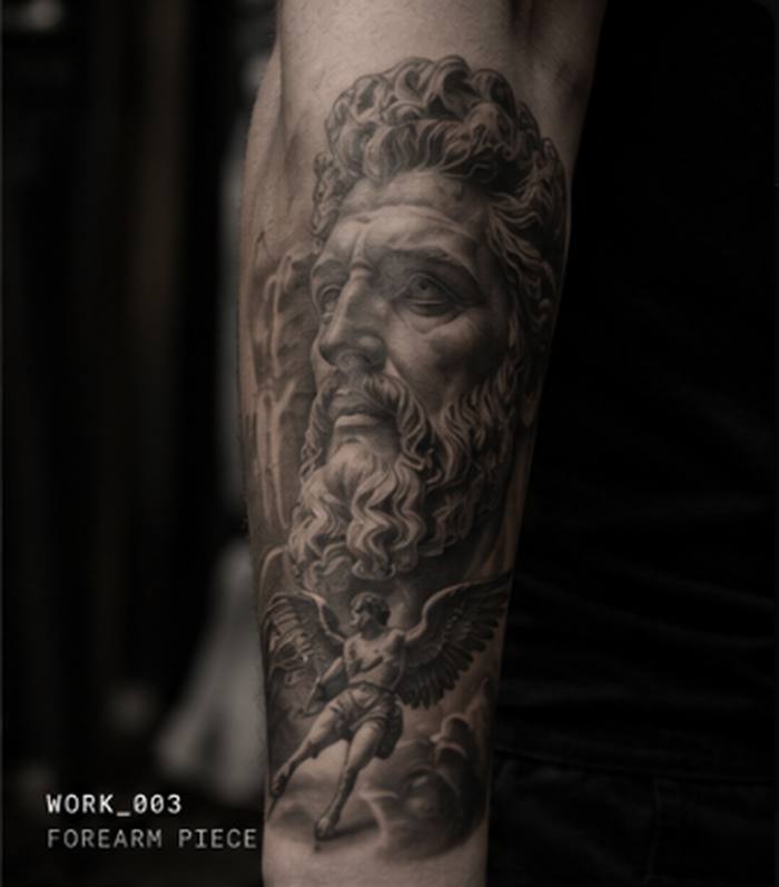 Black and grey realism tattoo of a bearded figure with an angel, forearm piece